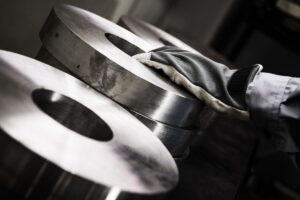 Gloved hand resting on large, hardened steel cylinders.